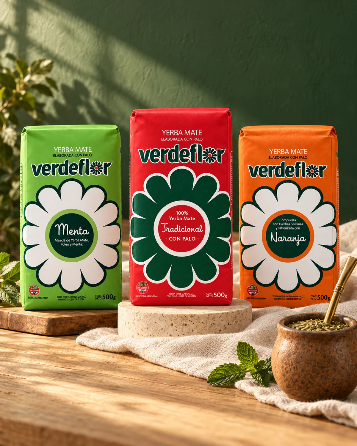 Selección de yerbas Verdeflor Tradicional, Menta y Naranja junto a un mate, sobre lino y madera